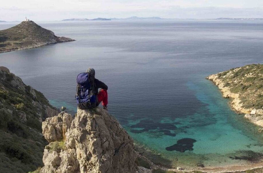 Karia Yolu kıyısında kayalıkta oturan sırt çantalı yürüyüşçü