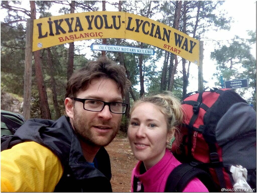 Likya Yolu başlangıç tabelası önünde iki yürüyüşçü